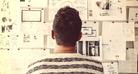 man lookin at wall full of notes